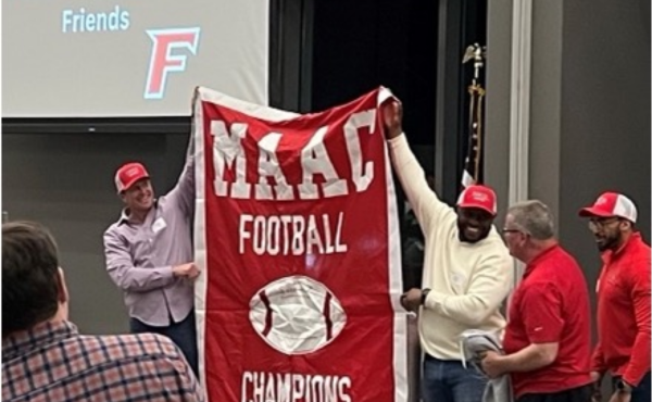 Alumni holding up a 1998 MAAC Football Championship banner.
